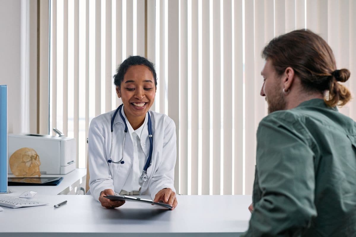 A young adult speaking with a doctor during a confidential consultation
